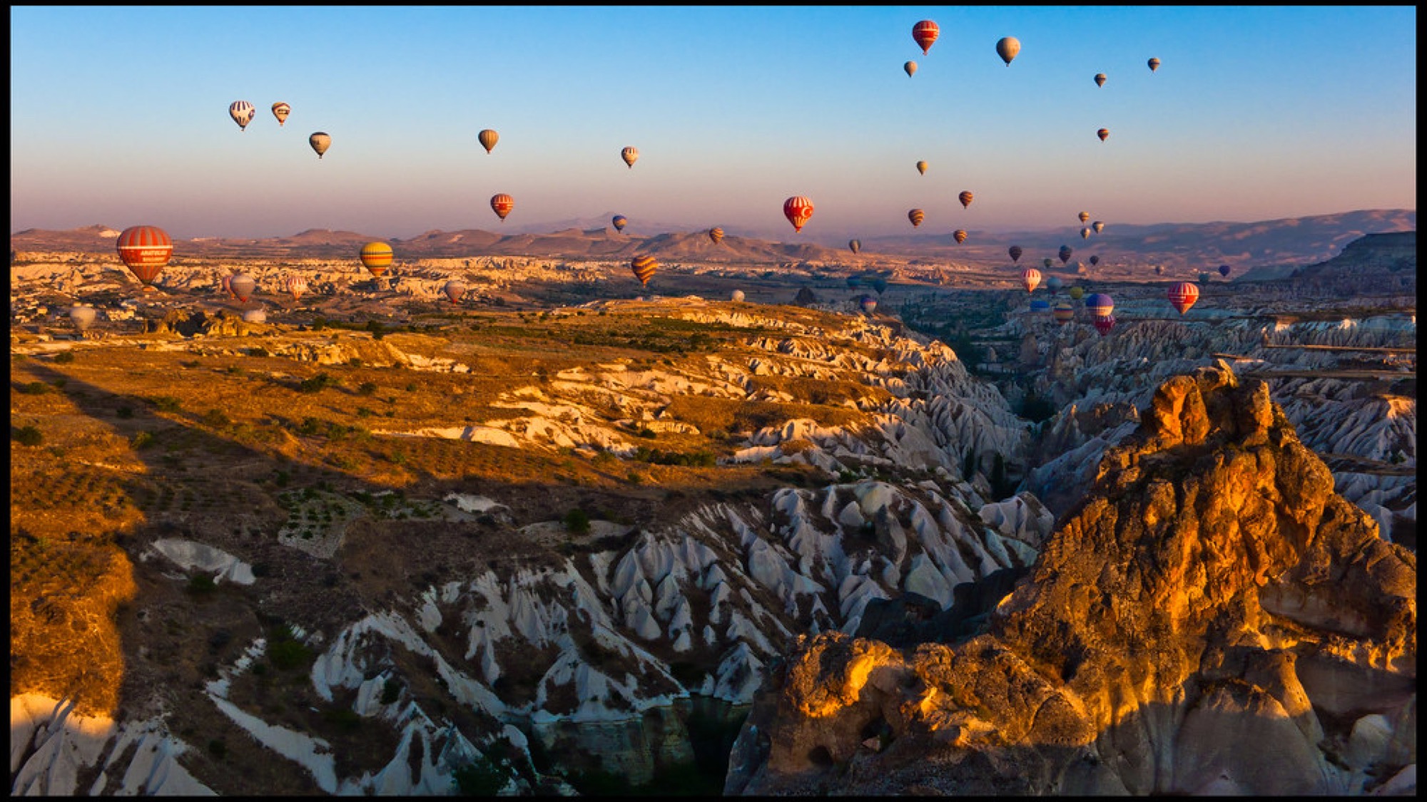 Balloons over the valleys of Cappadocia at sunrise